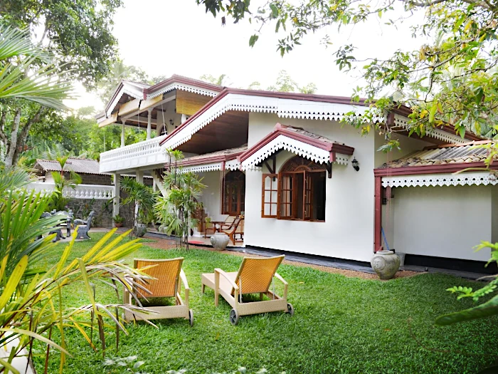 Villa und Garten mit Liegestühlen im Vordergrund